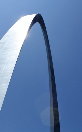 A creative corner shot from below a bright blue structure with a three-dimensional pattern adorning the walls. A concrete supporting pillar can be seen.