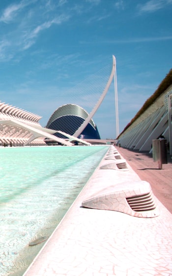 A creative corner shot from below a bright blue structure with a three-dimensional pattern adorning the walls. A concrete supporting pillar can be seen.